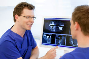 Arzt im Gespräch vor einem Röntgenbild. Praxis Foto.