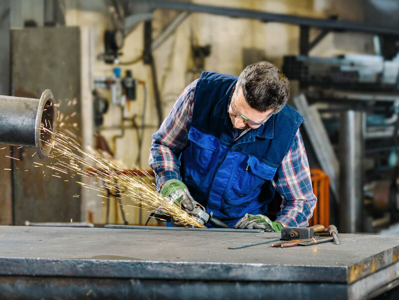 Corporate und Industrie Fotografie. Das Bild zeigt einen Handwerker bei Arbeiten in der Werkstatt.